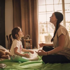 iStock image of mother and daughter practicing meditating in bedroom