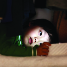 Stock image of child playing with mobile phone, Why & How Parents are Cutting Back Screen Time