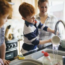 Kids doing chores in the kitchen; washing dishes