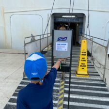 Little boy getting hand sanitizer outside cruise ship during coronavirus outbreak