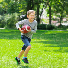 fitness apps for kids, iStock image of boy running with football