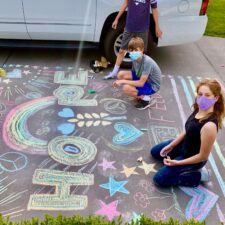 Kids with Chalk4Change decorating neighbors driveway