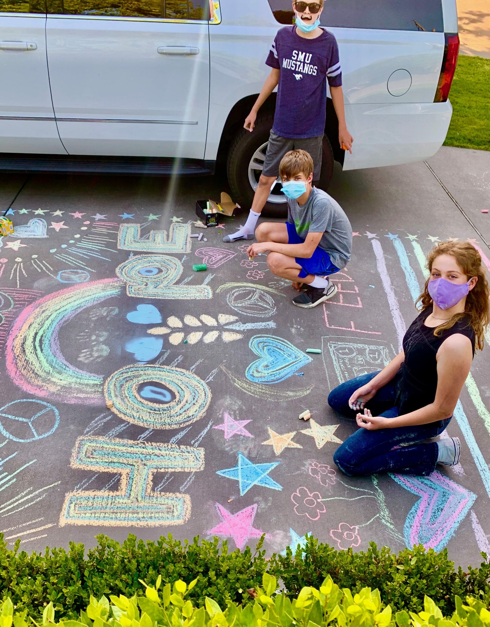 Kids with Chalk4Change decorating neighbors driveway
