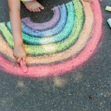 Girl drawing with chalk in the summer, summer brain drain, iStock