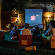 family watching Halloween movies in the backyard, iStock