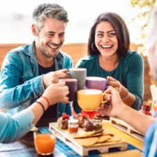 manners advice column on whether parents are obligated to be social with their kids' friends' parents. iStock image of adults toasting drinks at a coffee shop