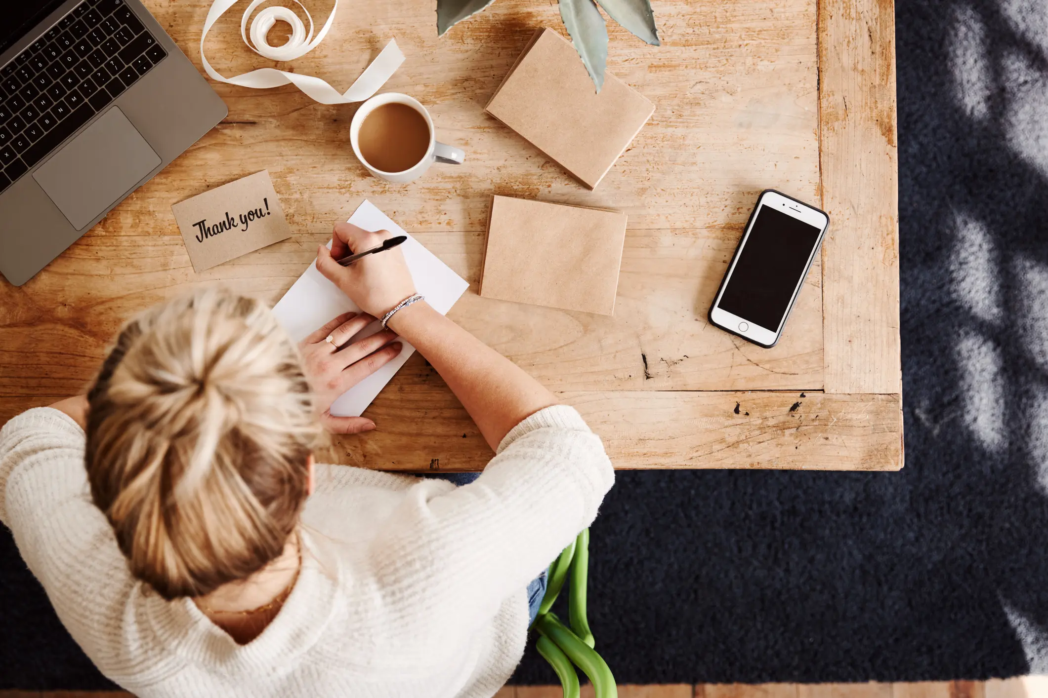 iStock image of woman writing thank-you notes, for manners advice column