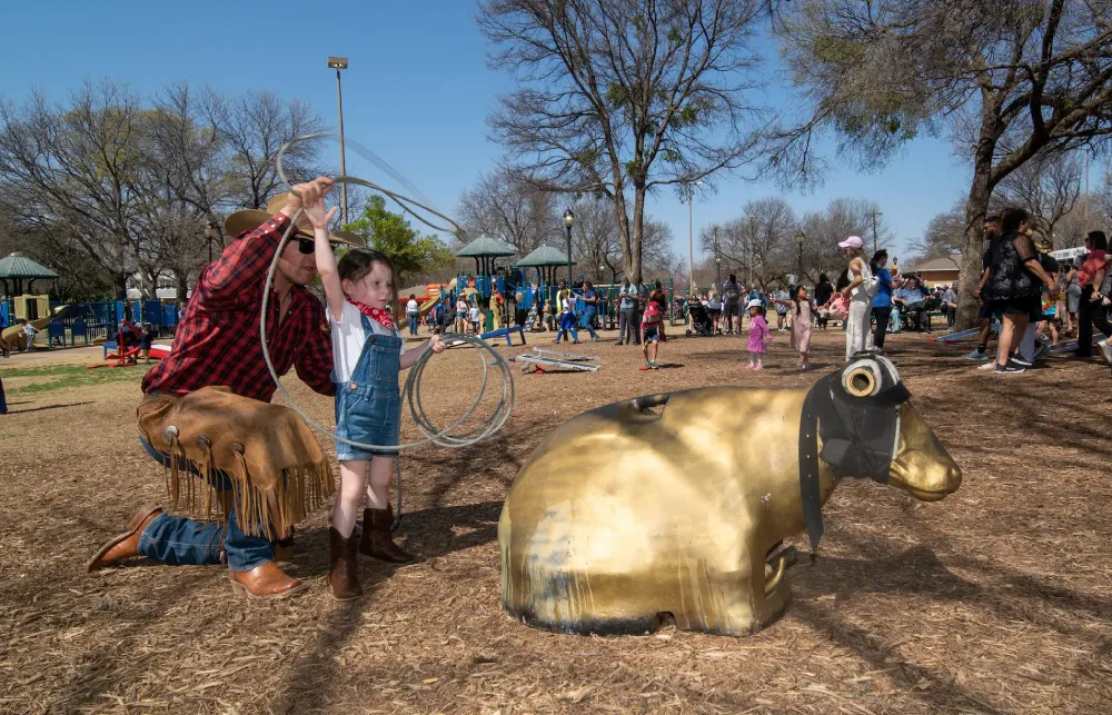 A young child learning to lasso a model bull at the Texas Forever Fest in Plano