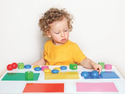 iStock image of Toddler playing with learning toys at home or kindergarten. Baby sorting organising objects blocks with specific colors. Early age education. Kids hand brain development activity for preschoolers, article on executive function