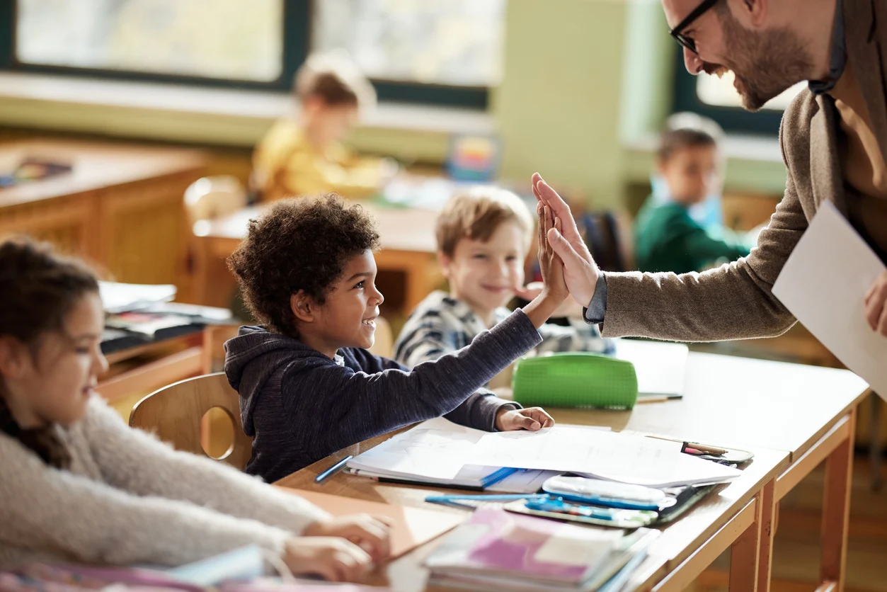 iStock image of children in classroom with teacher, making a good first impression with teacher