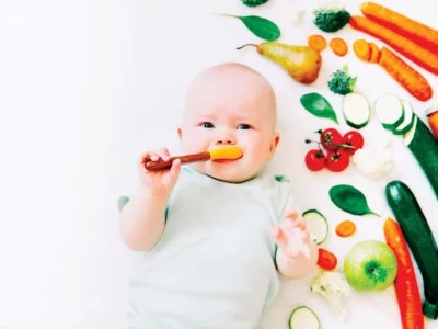 iStock image of baby eating soft, solid foods, for article on how to safely introduce common food allergens to your baby