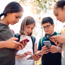 iStock image of children holding cellphones, for article on what parents can consider before giving their kids their own cell phone