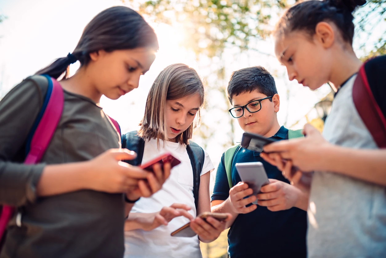 iStock image of children holding cellphones, for article on what parents can consider before giving their kids their own cell phone