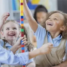 kids stacking blocks in classroom