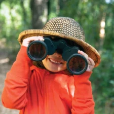 iStock image, child with hat and binoculars, for article on choosing the right summer camp for your child with special needs