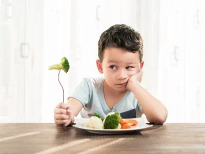iStock image of a child who's very unhappy with having to eat vegetables, for article on picky eating