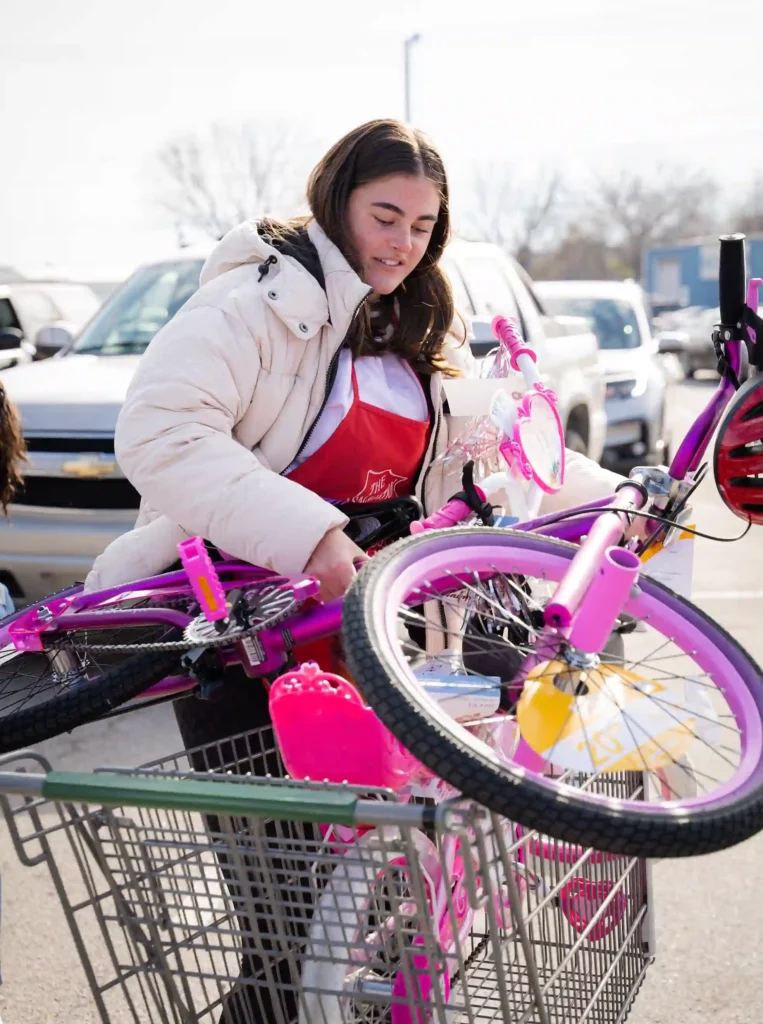 A volunteer loading a bicycle into a cart, for The Salvation Army's Christmas gift giving Angel tree program, photo courtesy The Salvation Army