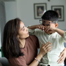 iStock image of a caring mother comforting her little crying son at home, for article on books about bullying to read with your children