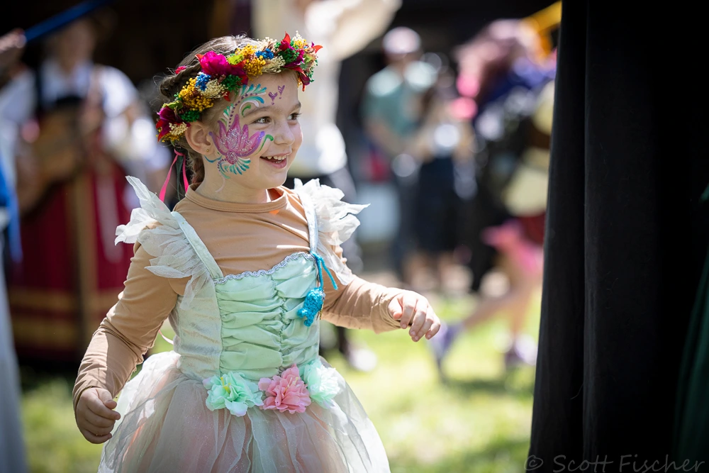 Little girl dressed up like a fairy with a flower crown and face painting, at Scarborough Renaissance Festival