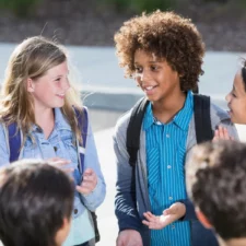 iStock image of students talking outdoors, for article on the 6-7 slang and social trend, with a Dallas counselor's advice for parents on how to set boundaries with their kids who just won't stop