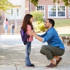 iStock image of father with daughter outside of a school building