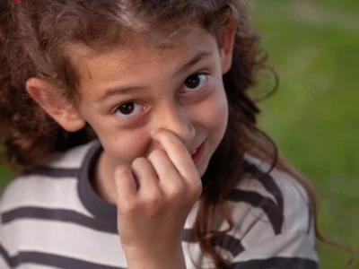 iStock image of young girl picking her nose and smiling