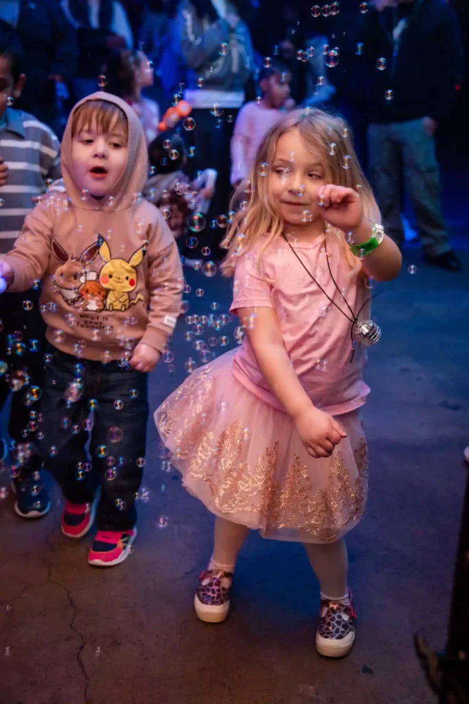 girl and boy dancing with bubbles at Disco Kids Dallas, photo courtesy April Barnes Photography