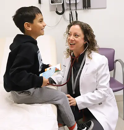Leslie Redden, RN, MSN, FNP-C, interacting with young male patient