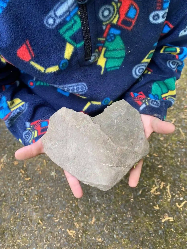 the son of managing editor Amanda Collins Bernier holding a heart-shaped rock