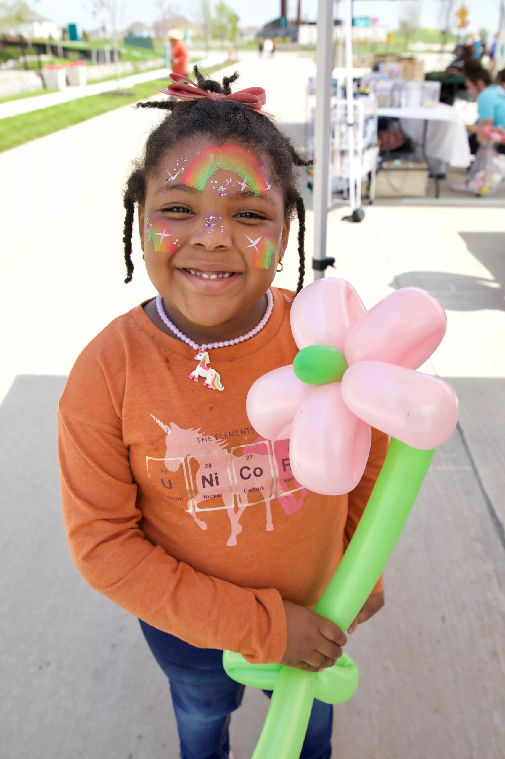 Girl with face painting and flower balloon at the Spring Stampede at Karis community, in Crowley, Texas