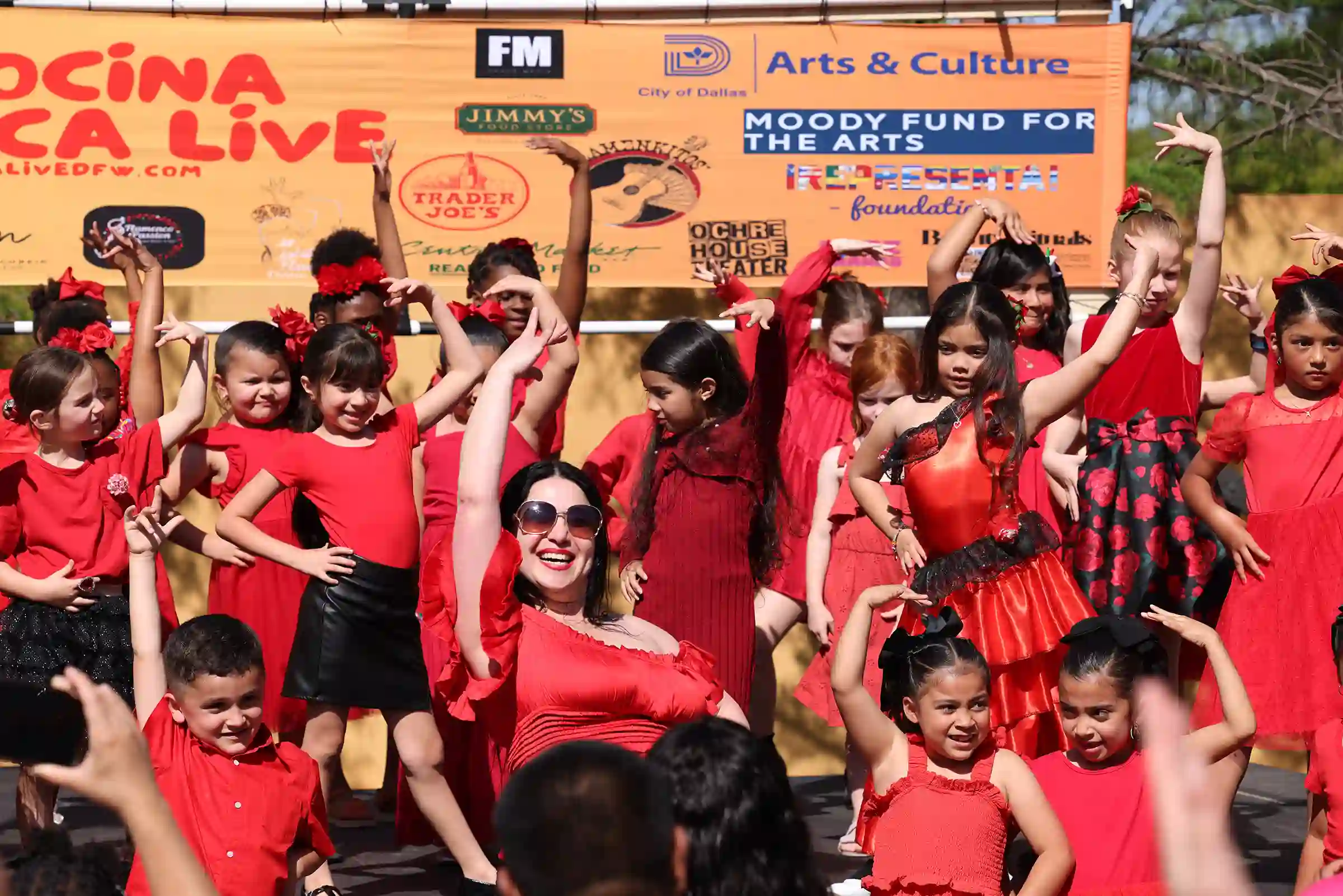 A teacher and students all dressed in red and dancing the flamenca